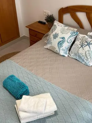 a bed with two towels and two pillows on it at V&M Canet in Canet de Berenguer
