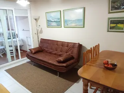 a living room with a brown couch and a table at V&M Canet in Canet de Berenguer