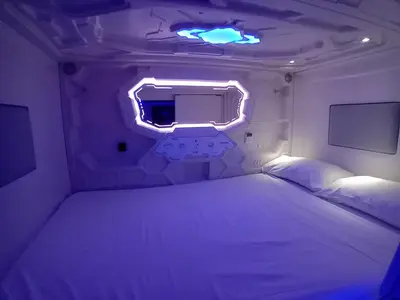 a bedroom with a bed in a room with lights at CAPSULE INN VALENCIA Hostel in Valencia