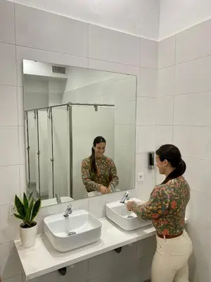 a woman standing in front of a bathroom mirror at CAPSULE INN VALENCIA Hostel in Valencia