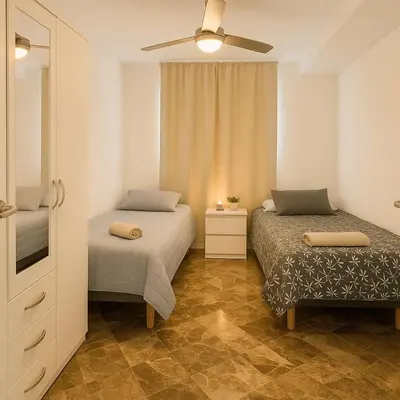 a bedroom with two beds and a ceiling fan at Del Mar three bed flat. in Puerto de Sagunto