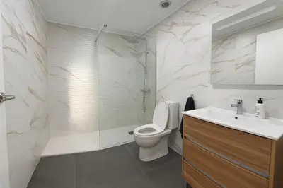 a bathroom with a toilet and a shower and a sink at Del Mar three bed flat. in Puerto de Sagunto