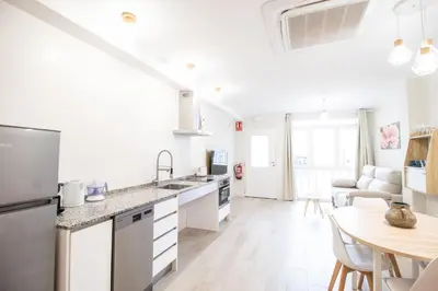 a white kitchen with a table and a dining room at Nautical Flats by Concept in Valencia