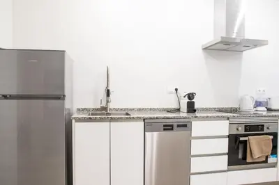 a kitchen with white cabinets and a stainless steel refrigerator at Nautical Flats by Concept in Valencia