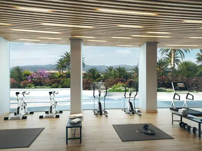 a gym with exercise bikes and a view of the water at Apartment Gran Canet by Interhome in Canet de Berenguer
