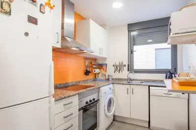 a kitchen with white cabinets and a washer and dryer at Confortable Beach Appartment with Views to the Sea in Puzol