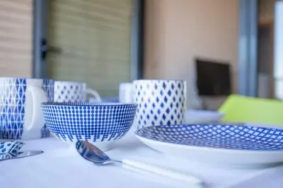 three blue and white bowls and spoons on a table at Confortable Beach Appartment with Views to the Sea in Puzol