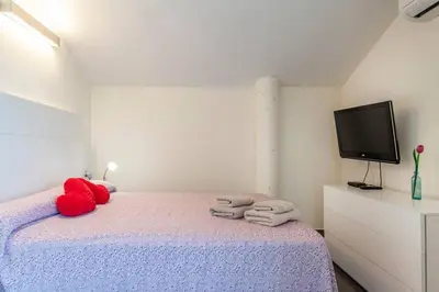 a bedroom with a bed with towels and a tv at Confortable Beach Appartment with Views to the Sea in Puzol