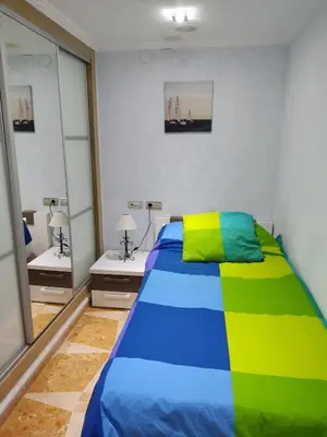 a bedroom with a colorful bed and two night stands at Faro Cullera primera Linea Playa del Dosel in Faro de Cullera