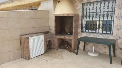 a small kitchen with a table and a fireplace at Faro Cullera primera Linea Playa del Dosel in Faro de Cullera