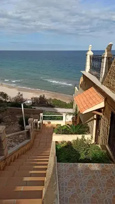 a view of the beach from a house with a staircase at Faro Cullera primera Linea Playa del Dosel in Faro de Cullera