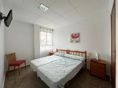 a bedroom with a bed and a red chair at Villa les palmiers in Rafelguaraf