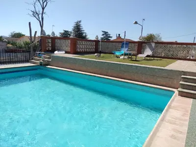 a swimming pool with blue water in a yard at Villa les palmiers in Rafelguaraf