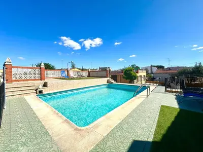 a swimming pool in the backyard of a house at Villa les palmiers in Rafelguaraf