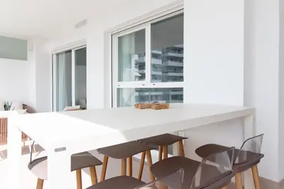 a white kitchen with a white table and chairs at Gran Apartment in Canet de Berenguer