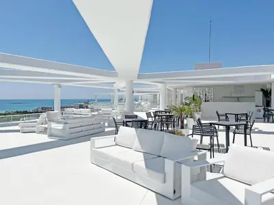a patio with white furniture and a table and chairs at Gran Apartment in Canet de Berenguer