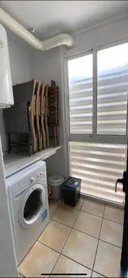 a laundry room with a washing machine and a window at Residencial Playa Canet in Canet de Berenguer
