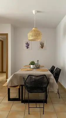 a dining room table with chairs and a pendant light at Residencial Playa Canet in Canet de Berenguer