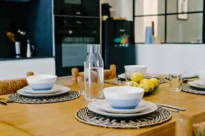 a wooden table with plates and bowls and a bottle at La Peregrina in Valencia