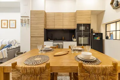 a kitchen and dining room with a wooden table and chairs at La Peregrina in Valencia
