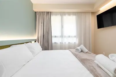a bedroom with a large white bed and a window at Apartamentos Las Ciencias H in Valencia