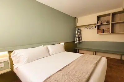 a bedroom with a white bed and a green wall at Apartamentos Las Ciencias A in Valencia