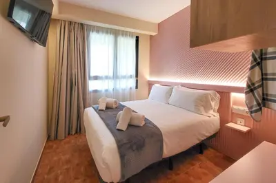a hotel room with a bed with two towels on it at Apartamentos Las Ciencias F in Valencia