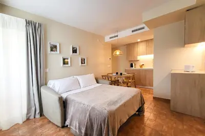 a bedroom with a bed and a kitchen with a table at Apartamentos Las Ciencias F in Valencia