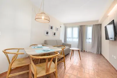 a dining room and living room with a table and chairs at Apartamentos Las Ciencias I in Valencia