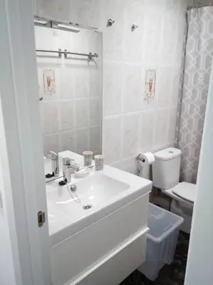 a white bathroom with a sink and a toilet at Spacious, 2 BR/2 BA, 3 Min walk to the beach in Cullera