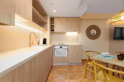 a kitchen with a sink and a table with chairs at Apartamentos Las Ciencias J in Valencia
