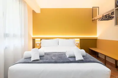 a bedroom with a large bed with white pillows at Apartamentos Las Ciencias J in Valencia