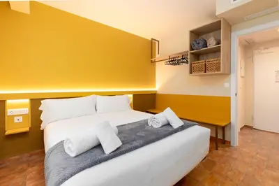 a bedroom with a large white bed with two towels at Apartamentos Las Ciencias J in Valencia