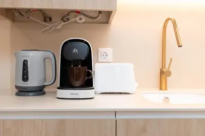 two coffeemakers sitting on a counter next to a sink at Apartamentos Las Ciencias K in Valencia