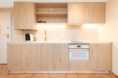 a kitchen with wooden cabinets and a white appliance at Apartamentos Las Ciencias K in Valencia