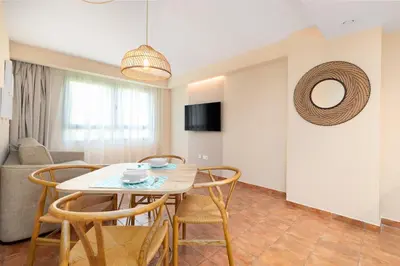 a dining room and living room with a table and chairs at Apartamentos Las Ciencias L in Valencia