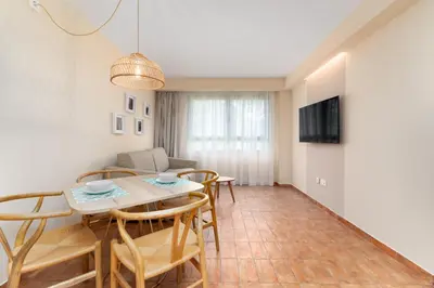 a dining room and living room with a table and chairs at Apartamentos Las Ciencias L in Valencia