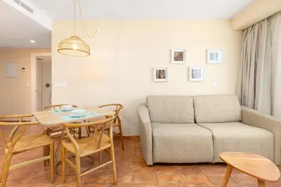 a living room with a couch and a table and chairs at Apartamentos Las Ciencias L in Valencia