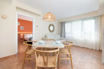 a dining room and living room with a table and chairs at Apartamentos Las Ciencias S in Valencia