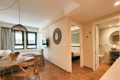 a living room with a dining room table and a bedroom at Apartamentos Las Ciencias B in Valencia