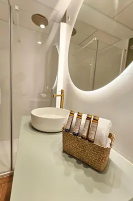 a bathroom with a sink and a basket of towels at Apartamentos Las Ciencias Studio G in Valencia