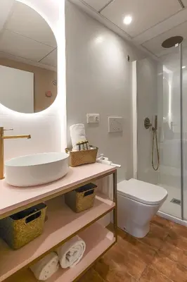 a bathroom with a sink and a toilet and a mirror at Apartamentos Las Ciencias E in Valencia