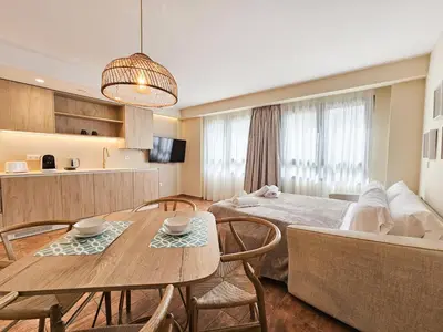a kitchen and a living room with a table and a couch at Apartamentos Las Ciencias Studio N in Valencia