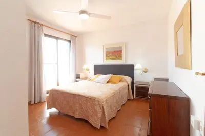 a bedroom with a bed and a dresser and a window at Global Vacacional, Adosado con piscina en la playa de Canet in Canet de Berenguer