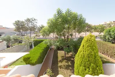 a view of a garden with trees and bushes at Global Vacacional, Adosado con piscina en la playa de Canet in Canet de Berenguer