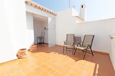 a room with two chairs and a table on a tile floor at Global Vacacional, Adosado con piscina en la playa de Canet in Canet de Berenguer