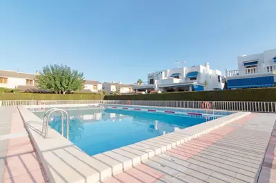a large swimming pool in front of a building at Global Vacacional, Adosado con piscina en la playa de Canet in Canet de Berenguer
