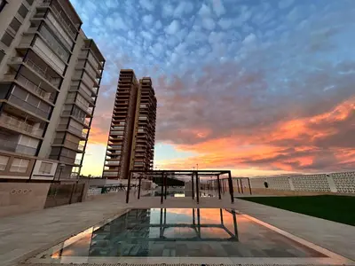a view of a building with a sunset in the background at Mareny de Barraquetes in Mareny Blau