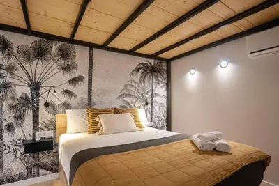 a bedroom with a bed and a wall with palm trees at Precioso Loft en Valencia in Valencia