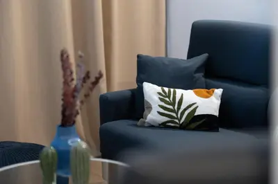 a blue chair with a pillow on it next to a table at DormForYou Alameda 12 Apartment in Valencia